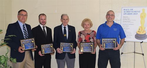 Hall of Achievement winners pose in a group with their plaques